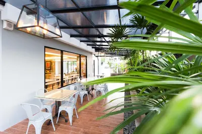 a patio with tables and chairs and plants at Baron Residence Bangkok in Bangkok