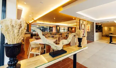 a dining room with a table with two birds on it at Baron Residence Bangkok in Bangkok