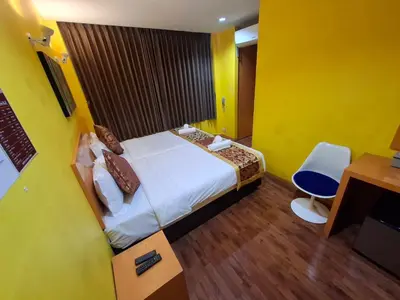 a hotel room with a bed and a desk and a chair at Wow Guesthouse in Bangkok