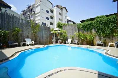 a large blue swimming pool in front of a building at Wild Orchid Villa Bangkok in Bangkok