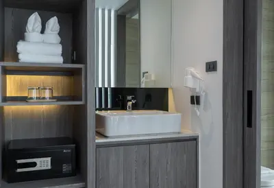 a bathroom with a sink and a mirror and towels at Amarin Hotel Rama 8 in Bangkok
