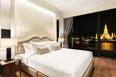 a bedroom with a large white bed and a balcony at ARUN Riverside Bangkok in Bangkok