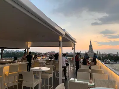 a balcony with tables and chairs and a view of the city at ARUN Riverside Bangkok in Bangkok