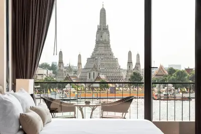 a room with a bed and a view of a building at ARUN Riverside Bangkok in Bangkok