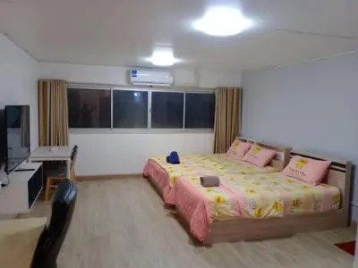 a bedroom with a large bed and a desk at K.NAT Room service in Nonthaburi