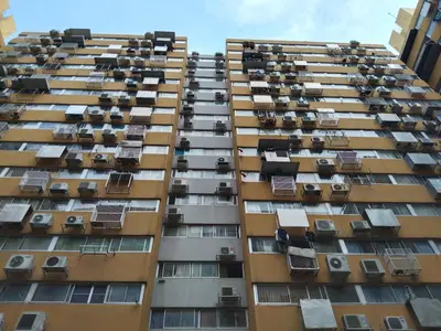 a tall apartment building with balconies and air conditioners at K.NAT Room service in Nonthaburi