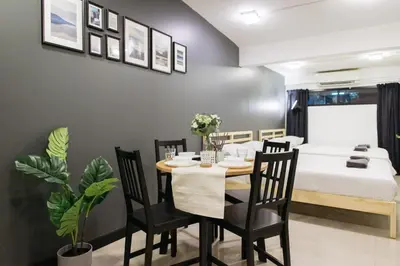 a dining room with a table and chairs and a bed at T1 Large Studio Full kitchen 100m. to BTS in Bangkok