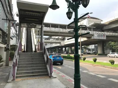 a blue car is driving down a street with a staircase at T1 Large Studio Full kitchen 100m. to BTS in Bangkok