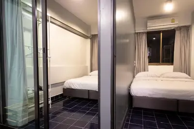 two beds in a small room with a window at T2 2 Bedrooms 6 guests Full kitchen 1 min to BTS in Bangkok