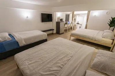 a hotel room with two beds and a kitchen at B2 Large + Comfort full kitchen near MRT Bangson in Bangkok