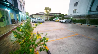 a parking lot with cars parked on the street at The Willing Hotel and Residence in Lak Si