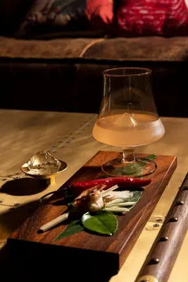 a wine glass and vegetables on a wooden table at MeStyle Museum Hotel in Bangkok