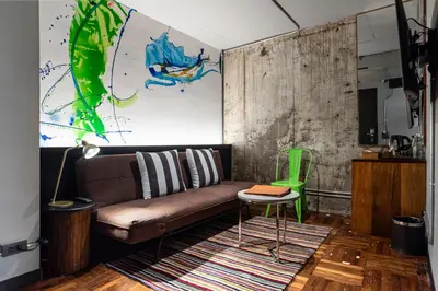 a living room with a brown couch and a green chair at MeStyle Museum Hotel in Bangkok