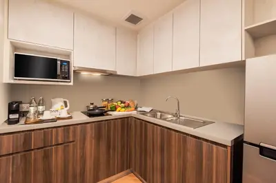 a kitchen with a sink and a microwave at Amanta Hotel & Residence Sathorn in Bangkok