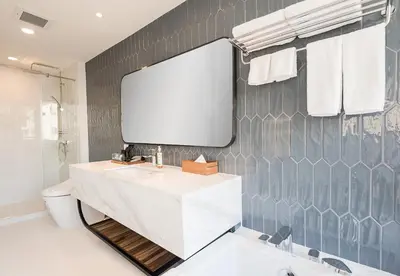a bathroom with a white sink and a mirror at Amanta Hotel & Residence Sathorn in Bangkok