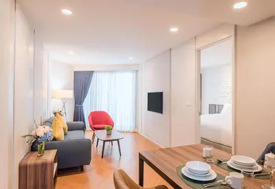 a living room with a couch and a table at Amanta Hotel & Residence Sathorn in Bangkok