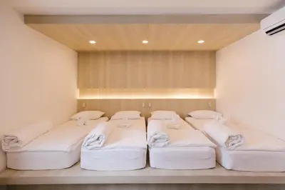 a room with four beds in a room at Nappiness Hotel in Bangkok
