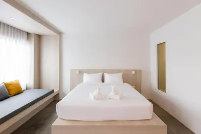 a bedroom with a white bed and a window at Nappiness Hotel in Bangkok