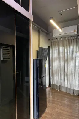 a kitchen with a black refrigerator in a room at 44 Room Rama 3 in Bangkok
