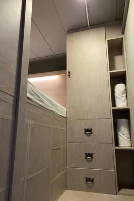 a walk in closet with wooden doors and shelves at 44 Room Rama 3 in Bangkok