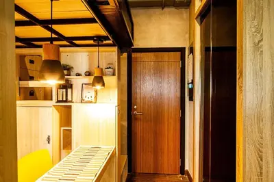 a room with a wooden door and a room with a bed at 44 Room Rama 3 in Bangkok
