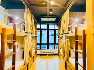 a room filled with bunk beds with a large window at Daraya Hostel in Bangkok