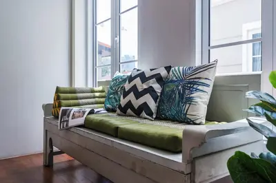 a couch with pillows on it in a room with windows at MIQ Asoke808 Villa - Asoke BTS - garden pool - 16 Pax in Bangkok