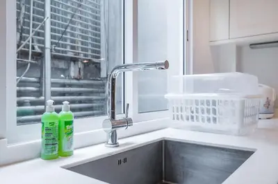 a kitchen sink with two bottles of detergent next to a window at MIQ Asoke808 Villa - Asoke BTS - garden pool - 16 Pax in Bangkok