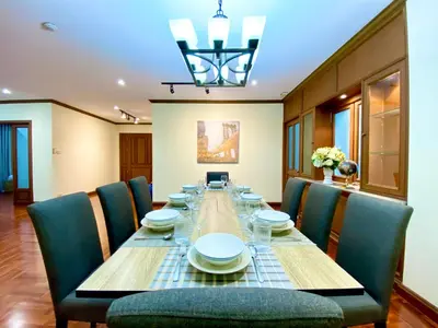a dining room with a long table and chairs at NT Place Sukhumvit Suites in Bangkok