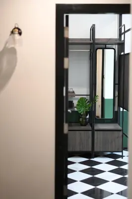 a room with a black and white checkered floor and a plant at KLYDE Boutique - Chatuchak in Bangkok