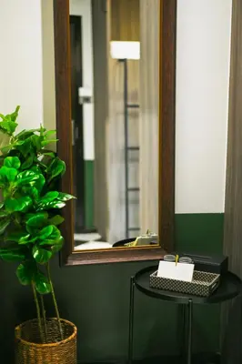 a mirror and a table with a candle and a plant at KLYDE Boutique - Chatuchak in Bangkok