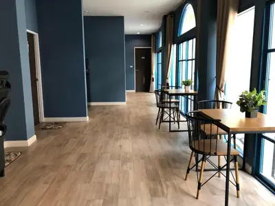 a room with tables and chairs and blue walls at Mangkon Hostel in Bangkok