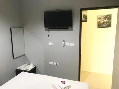 a room with a bed and a tv on the wall at HARRYS RESIENDENCE in Bangkok