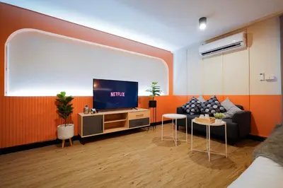a living room with a couch and a flat screen tv at Saffron Hill Bangkok in Bangkok