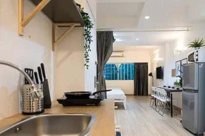 a kitchen with a sink and a living room at B3 Cosy Studio /5 guests/ Near MRT/full kitchen in Bangkok