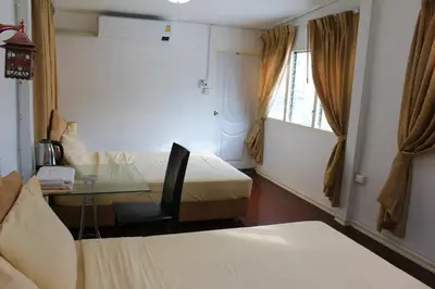 a hotel room with a table and a bed and a window at C U Again in Bangkok