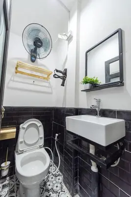 a bathroom with a toilet and a sink and a fan at Mein Haus B @Bangpo in Bang Su