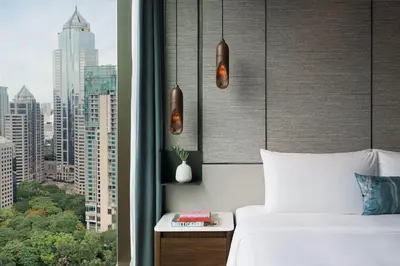 a bedroom with a bed and a view of a city at Kimpton Maa-Lai Bangkok by IHG in Bangkok