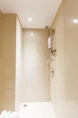 a bathroom with a shower with a shower head at D Day Suite in Bangkok