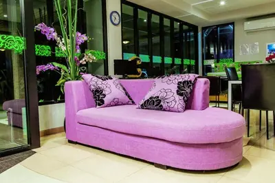a purple couch with pillows in a store at D Day Suite in Bangkok