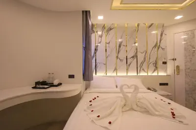 a bedroom with a bed with a towel on it at Pratunam Atrium Hotel in Bangkok