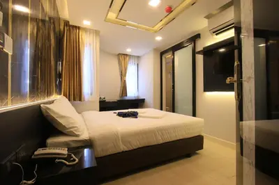 a hotel room with a bed and a telephone at Pratunam Atrium Hotel in Bangkok