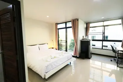 a bedroom with a bed and a large window at Baanrao Bangson in Bangkok
