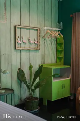 a room with birds on the wall and a plant at Tang House in Bangkok