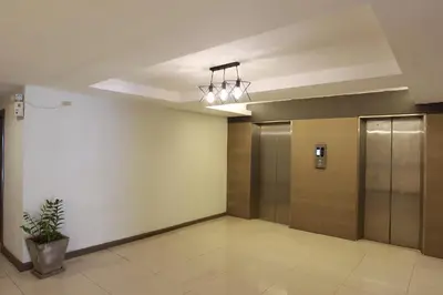 a room with a hallway with doors and a potted plant at Lee Garden Bangkok in Bangkok