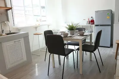 a kitchen with a table with chairs and a refrigerator at Airee Premier Residence in Bangkok