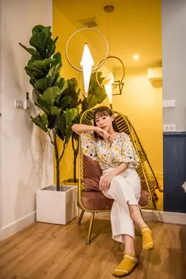 a woman sitting in a chair next to a plant at Theme Boutique Hotel Bangkok in Bangkok