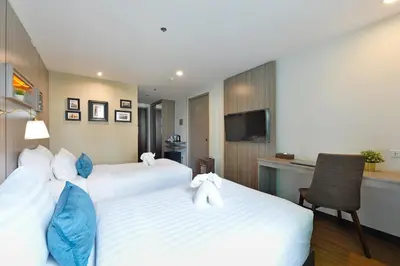 a hotel room with two beds and a kitchen at StayAt Bedever Bangkok Hotel in Bangkok