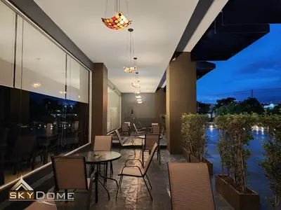 a patio with a table and chairs on a balcony at Sky dome resotel - โรงแรมสกายโดม รีโซเทล in Bangkok