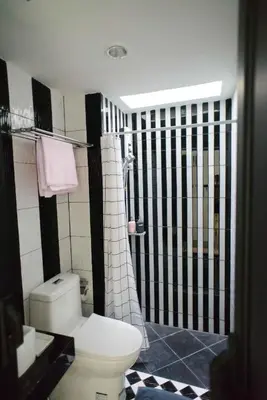 a bathroom with a white toilet and a shower at 87 Oldtown at River Pier in Bangkok